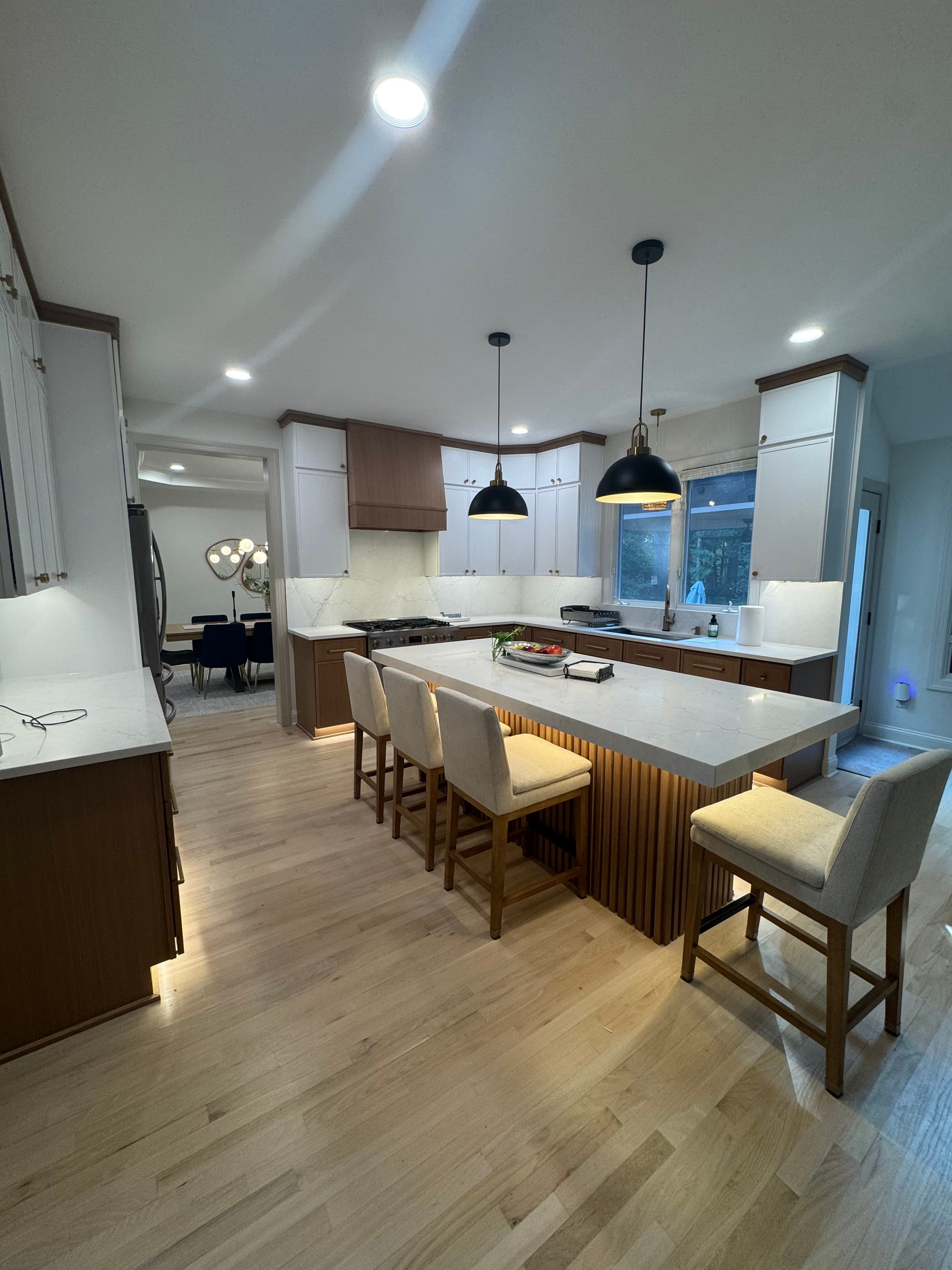 Two-tone kitchen remodel with white upper cabinets, wood lower cabinets, fluted island, and hardwood floors in Charlotte NC
